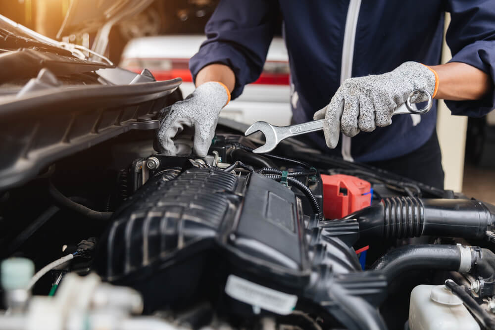 a guy fixing the car and maintain the car with engine